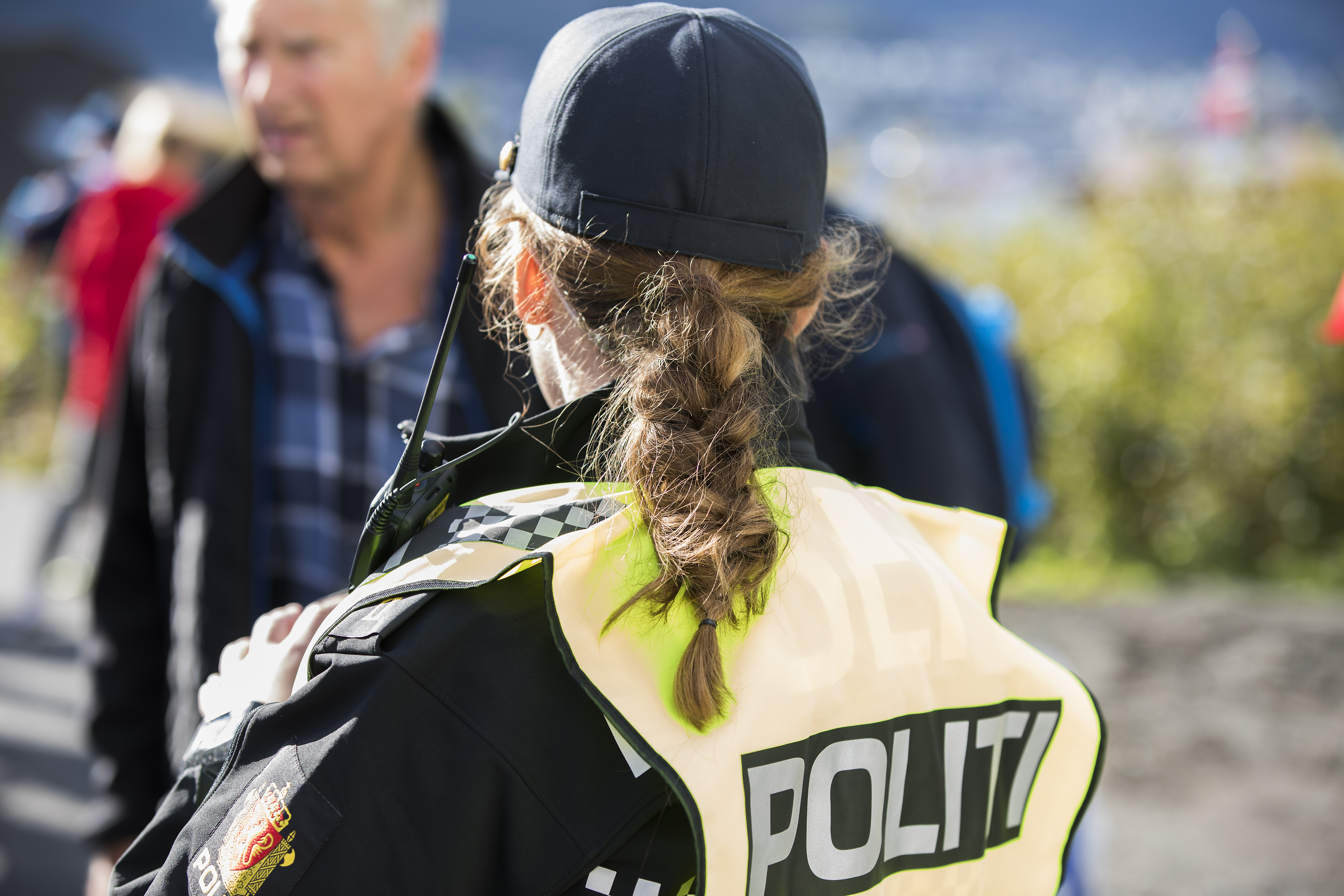 Kvinnelig politibetjent med refleksvest og ryggen til kamera Foto Torkjell Trædal